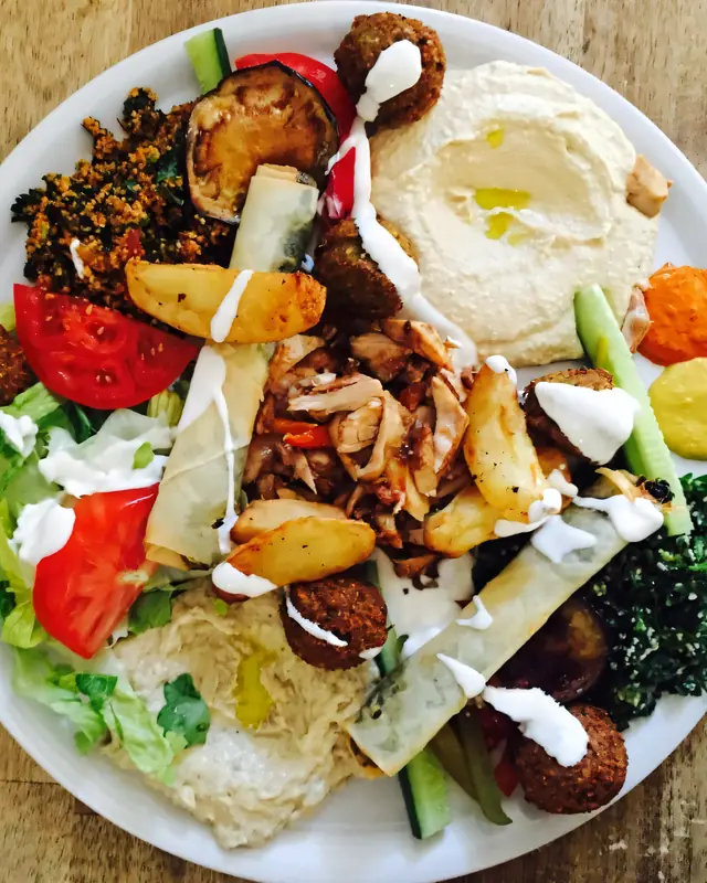 Gefüllter Teller mit Falafel, Gemüse und Hummus