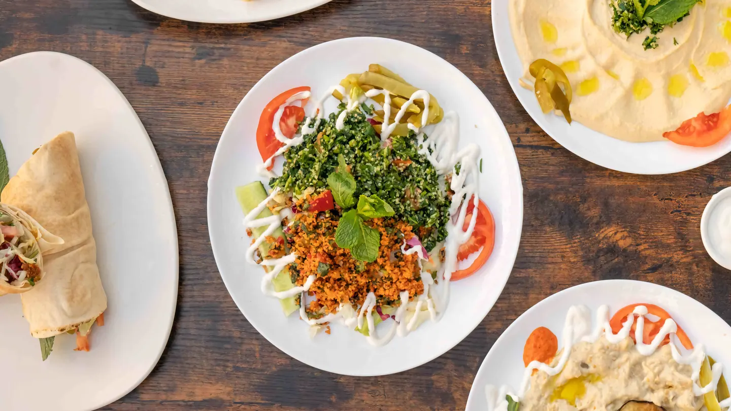 Gedeckter Tisch bei ShuShu Falafel mit Wrap, Tabuleh, Hummus und Mutabbal